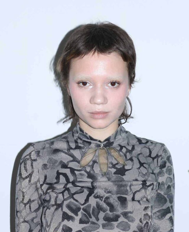 portret młodej kobiety na białej ścianie