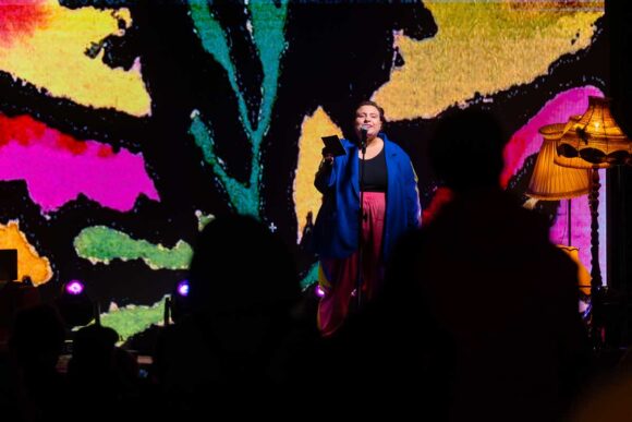 Kobieta na scenie na tle kolorowej grafiki