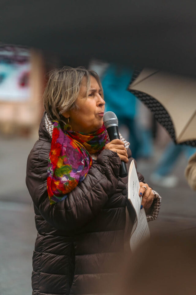 Kobieta mówiąca do mikrofonu na ulicy