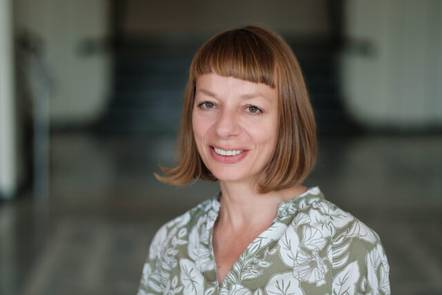 Monika Bobako-uśmiechnięta kobieta z włosami do ramion i krótką grzywką