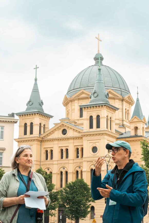 Kobieta i mężczyzna - przewodnicy - na tle kościoła