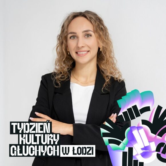 Młoda kobieta, z długimi blond włosami, w czarnej marynarce na jasnym neutralnym tle
