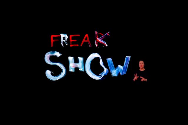 Stopklatka. Napis Freak Show, tłumacz języka migowego w prawym dolnym rogu